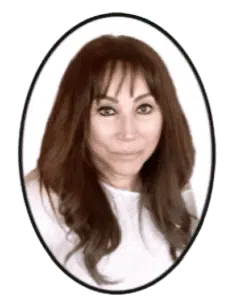 A woman with long hair and bangs in front of a green background.