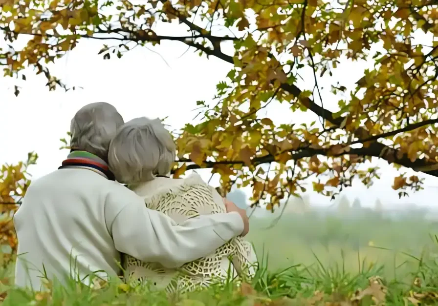 A couple of people sitting on top of a grass covered field.